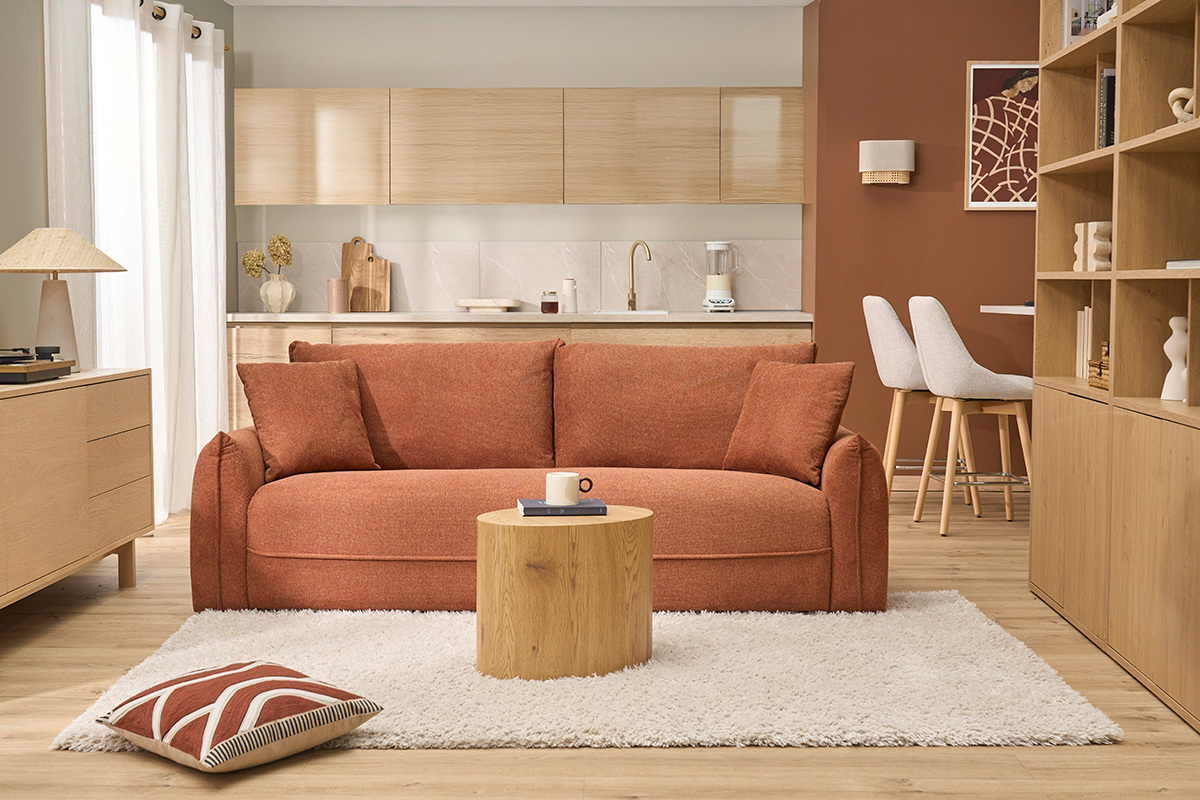Salon moderne avec applique murale en lin beige et rotin, canap� orange et table basse en bois.