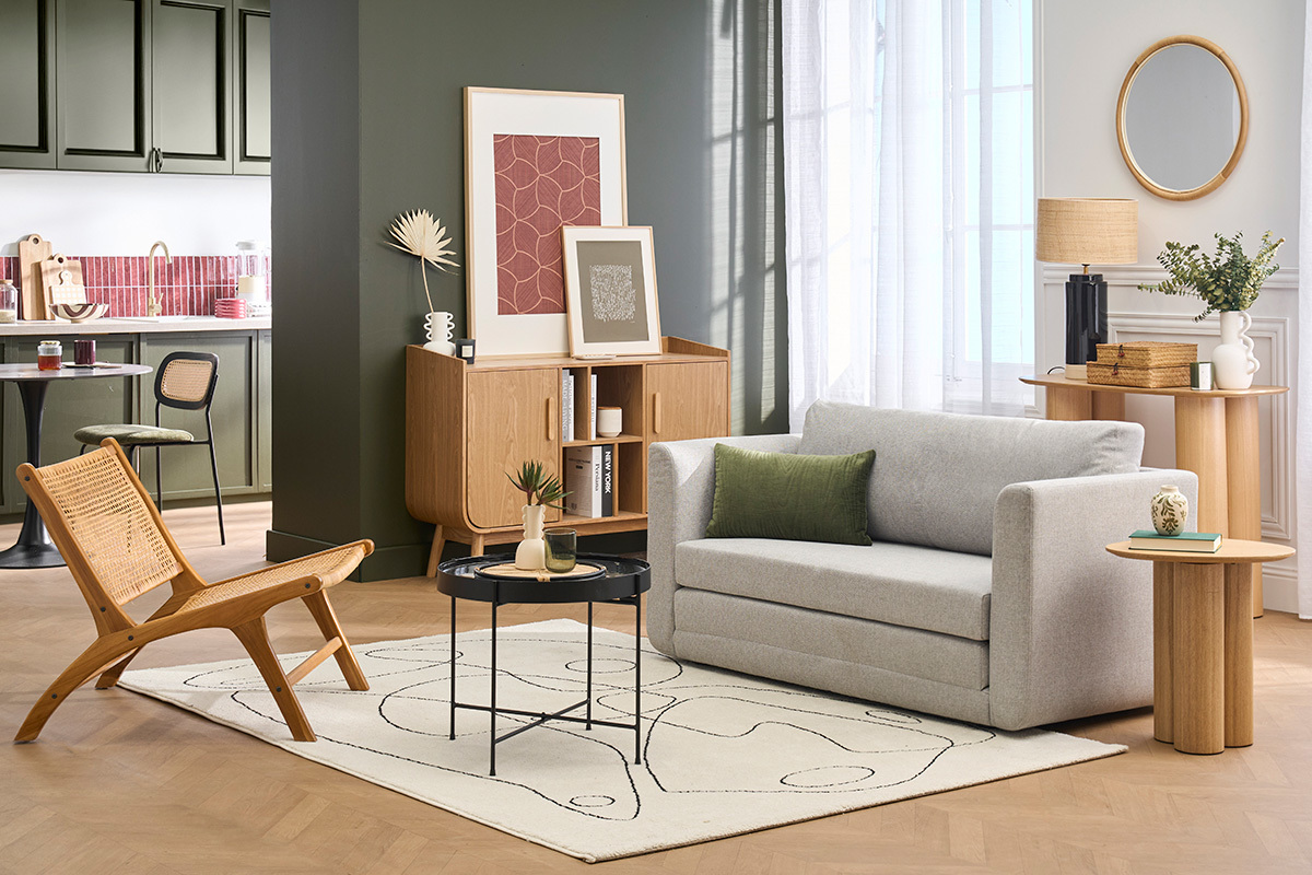 Salon avec canap� convertible 2 places en tissu gris clair, table basse noire, et chaise en bois.