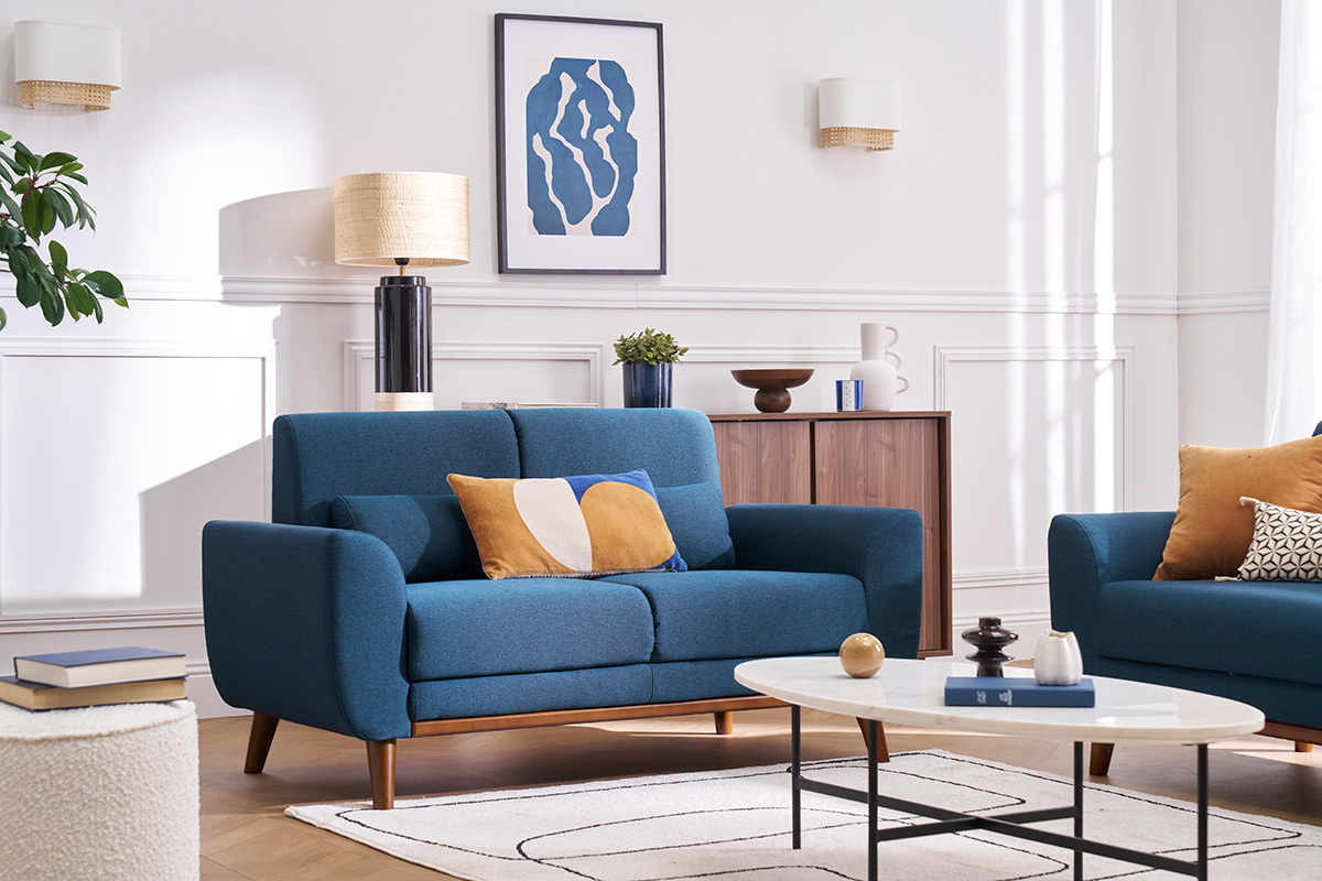 Canap� 2 places EKTOR en tissu bleu avec coussins, angle de vue de trois-quarts.