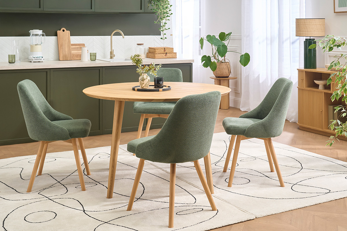 Chaises scandinaves vert kaki et bois clair autour d'une table ronde.