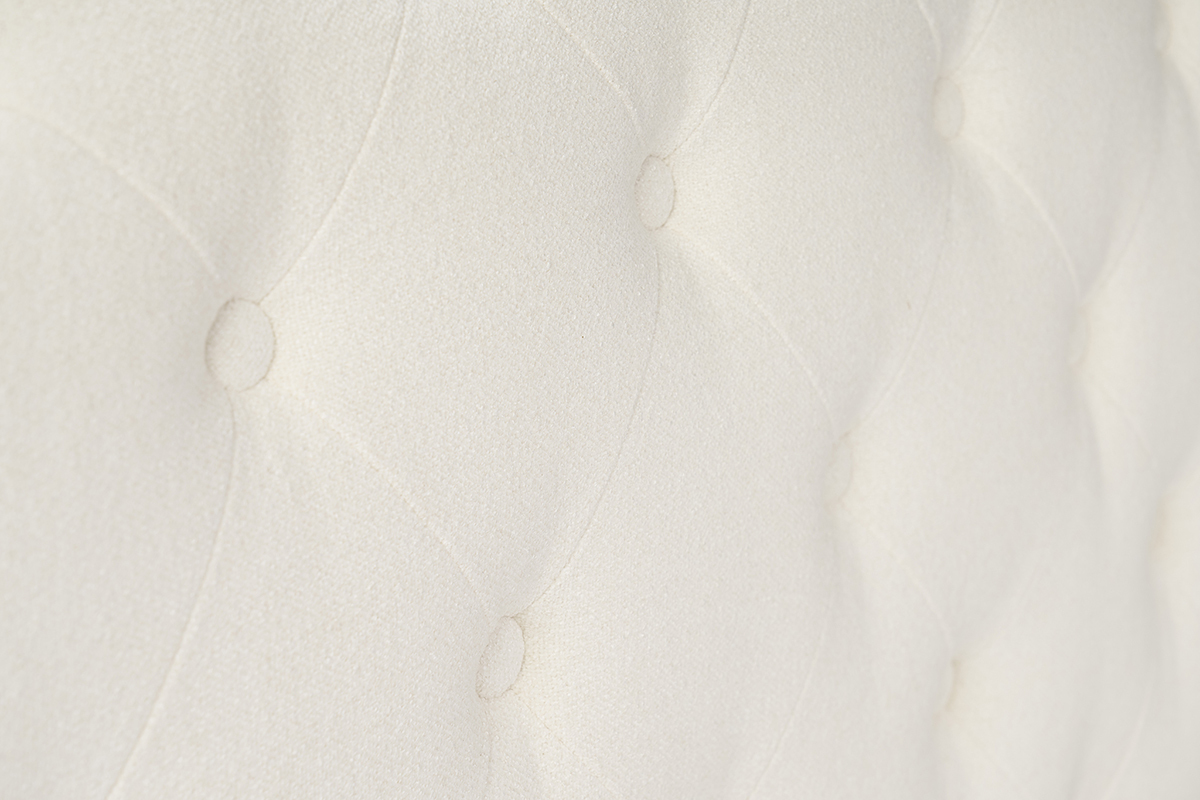 T�ti�re du lit capitonn� en velours beige avec boutons, vue de pr�s.