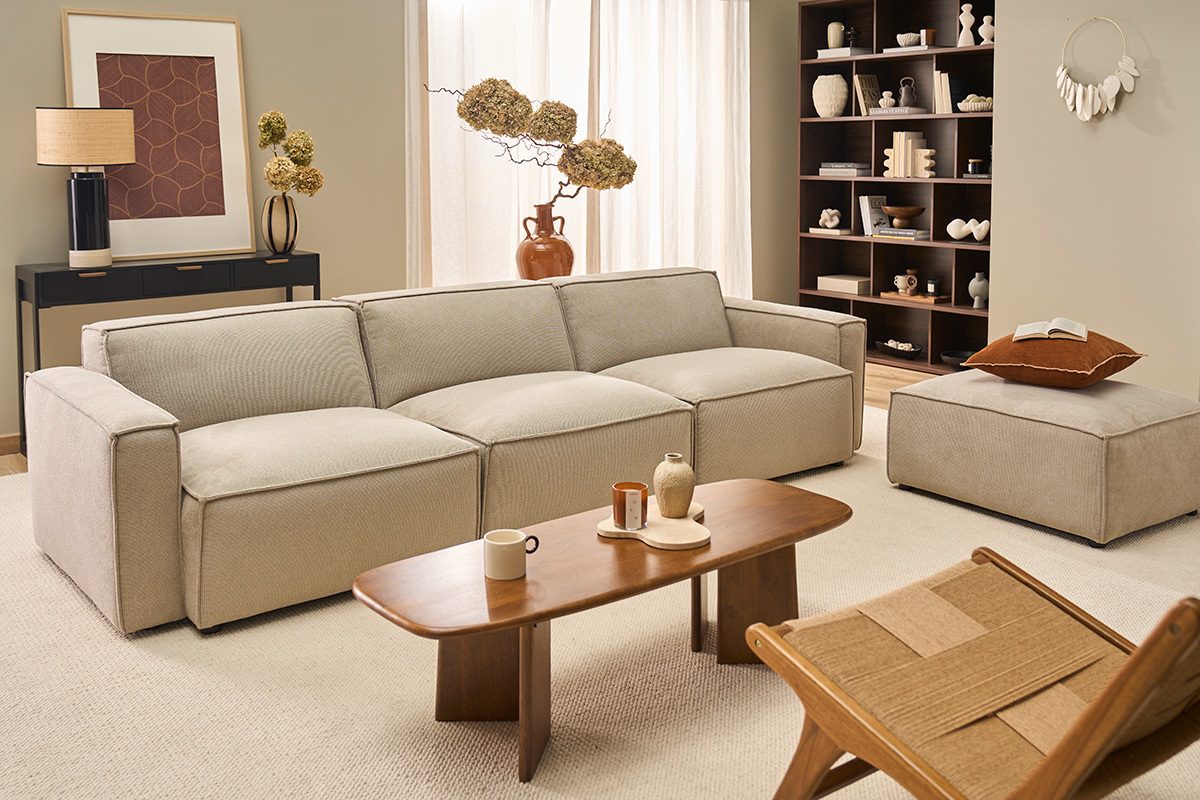 Canap� en tissu chenille beige avec table basse en bois dans un salon moderne.