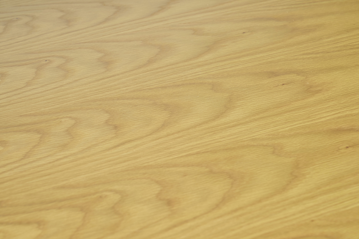 Gros plan sur le plateau en bois clair de la table LEENA.