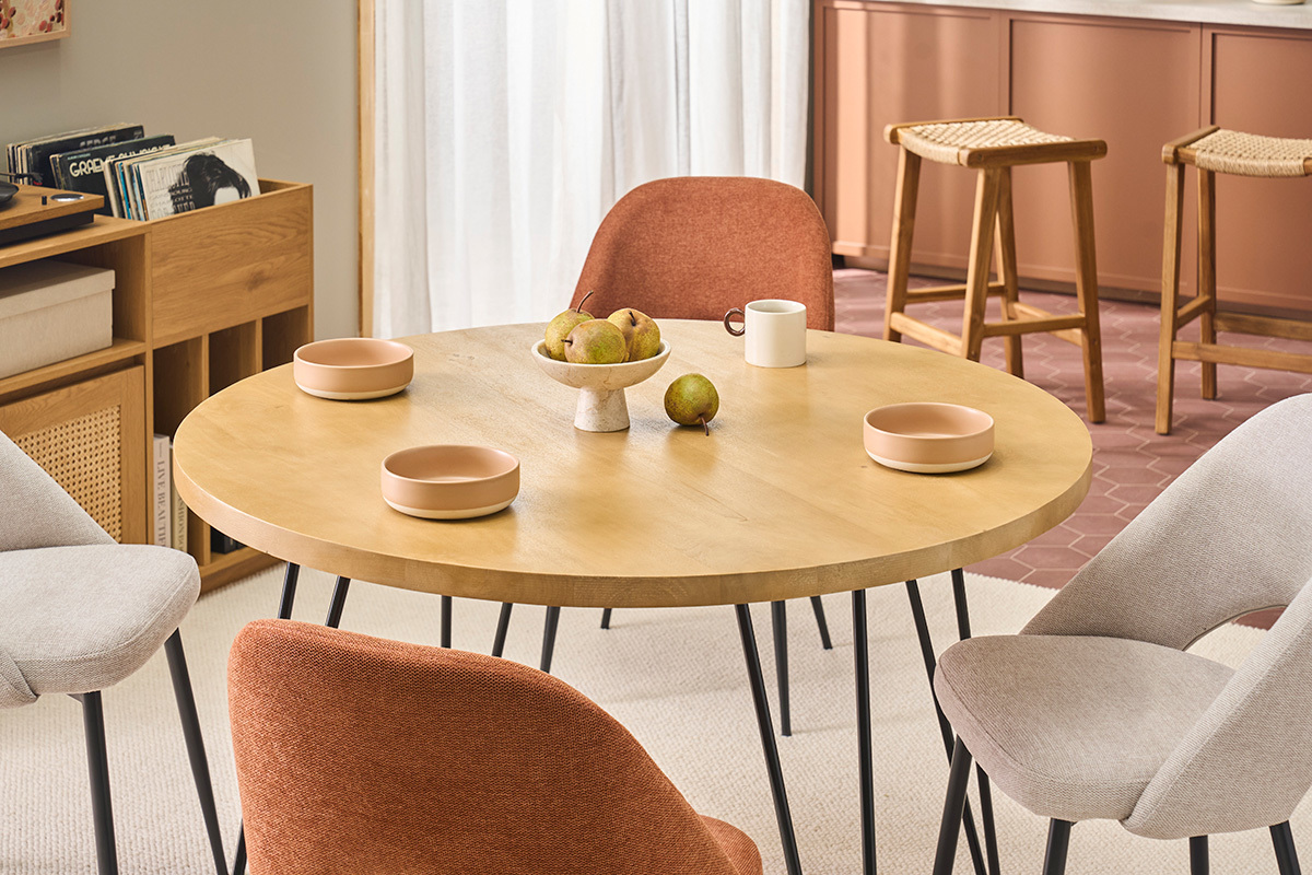 Table ronde en manguier avec assiettes, chaises et d�cor de cuisine.