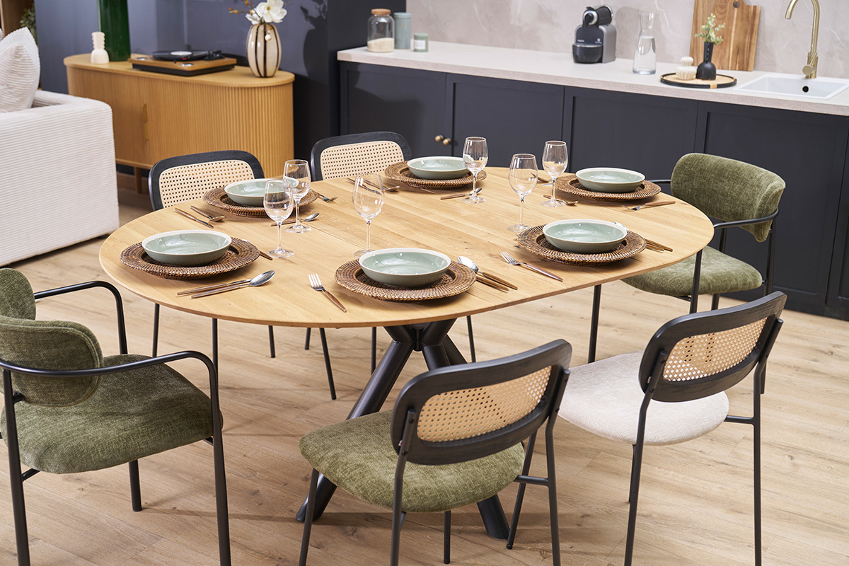 Table � manger extensible en bois clair ch�ne, vue d'angle, avec couverts et assiettes.