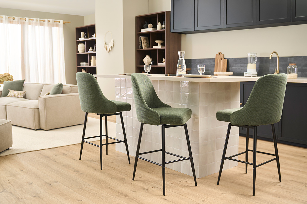 Tabourets de bar HASTA en tissu vert, vue de profil dans une cuisine moderne avec bar.