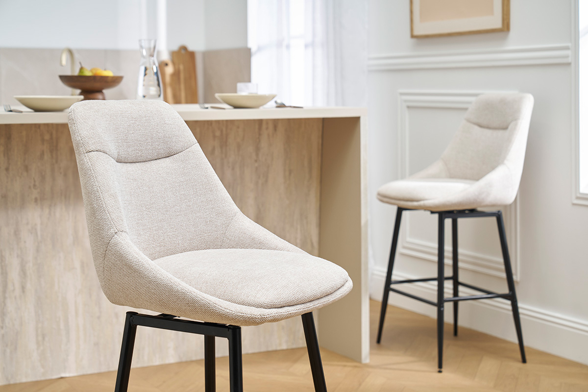 Tabourets de bar beige effet velours, vue 3/4, devant un comptoir.